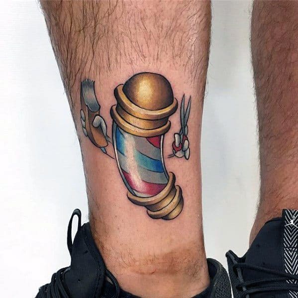 Classic cartoon-style tattoo of a barber pole with animated hands holding scissors and a clipper on the back of the leg.