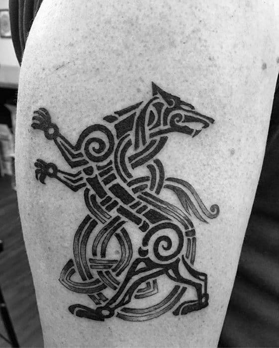 Celtic wolf tattoo on upper arm with bold black knotwork forming a stylized upright wolf in a dynamic, mythical pose.