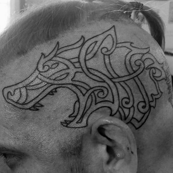 Celtic wolf head tattoo on shaved scalp with bold black linework and flowing knot patterns forming a fierce, stylized silhouette.