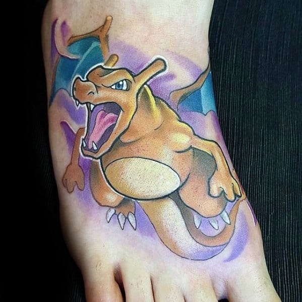 Bold Charizard foot tattoo with open mouth and teal wings, set against a purple aura for a dramatic and energetic look.