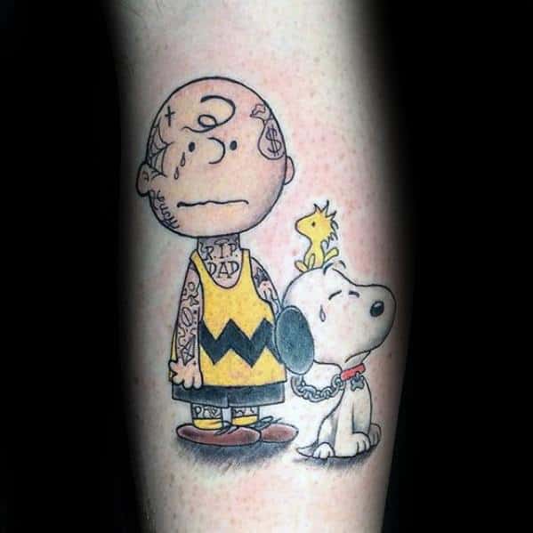 Edgy Charlie Brown tattoo featuring a tough look with tattoos, teardrops, and 'RIP Dad' on his shirt, alongside Snoopy and Woodstock.