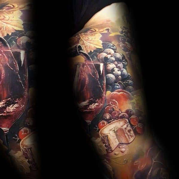 Realistic full-sleeve tattoo featuring a wine glass, grapes, and a wheel of cheese, with rich colors, smooth shading, and intricate details.