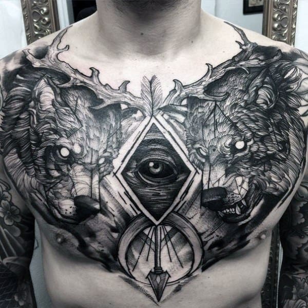 Intricate chest tattoo of two wolves flanking an all-seeing eye and geometric elements, symbolizing duality, intuition, and inner strength.