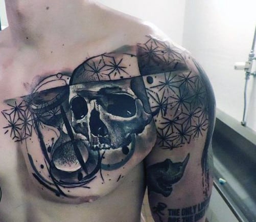 Skull and geometric tattoo on a person's chest and shoulder