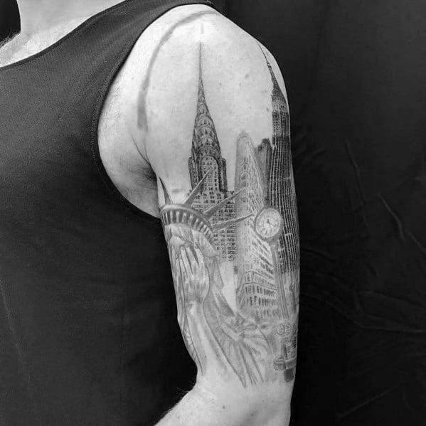 Black-and-grey Chrysler Building tattoo with the Statue of Liberty and NYC landmarks, creating a dynamic and detailed sleeve design.