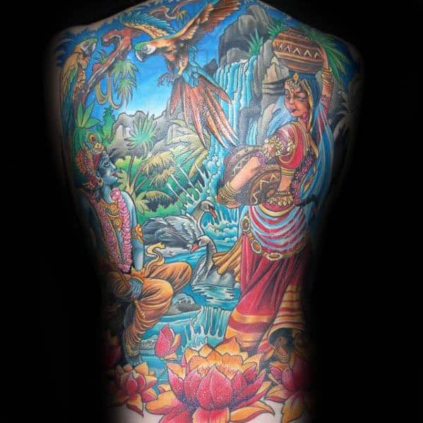 Vibrant full-back Krishna tattoo depicting Krishna playing the flute for Radha in a lush forest scene with waterfalls, lotus flowers, and birds.