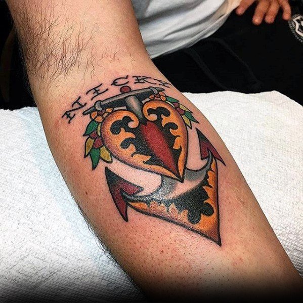 Colorful anchor tattoo on forearm with vibrant flowers and meaningful text above