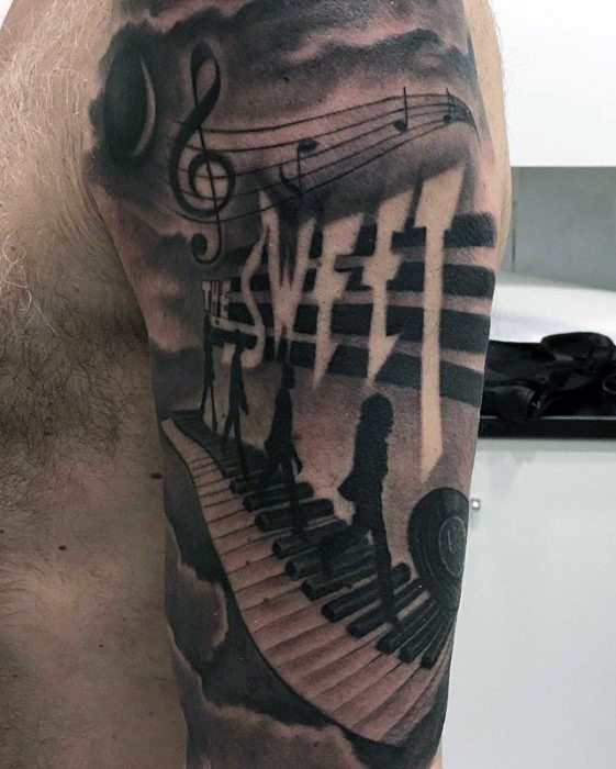Surreal Beatles tattoo with shadowed Abbey Road silhouettes walking on a piano path, featuring musical notes, clouds, and "The Beatles" text.