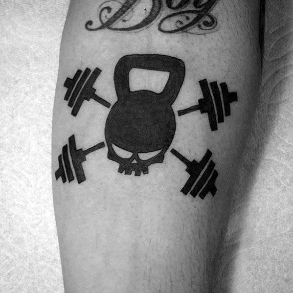 Bold black tattoo of a kettlebell with a skull design, crossed by four barbells, symbolizing hardcore strength, grit, and warrior spirit.