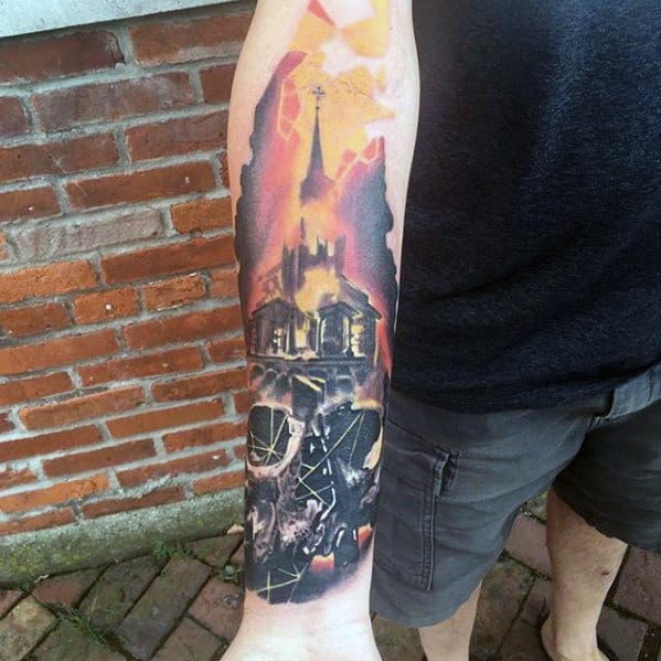 Realistic burning church tattoo with glowing fire and smoke above a shattered skull. Dark, dramatic tones cover the forearm in a vivid scene.