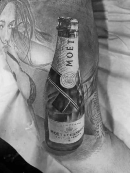 Black and white tattoo of a Moet & Chandon champagne bottle on a person's arm, with a partial image of a woman's face in the background.