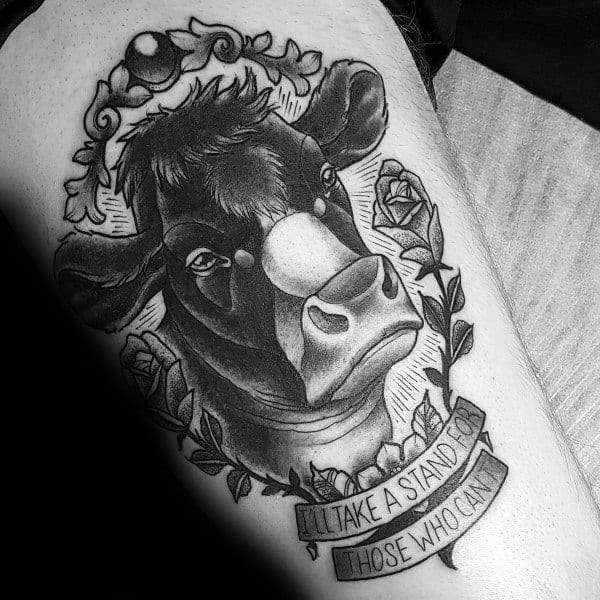 Black and grey cow portrait tattoo framed with roses and leaves, featuring a banner that reads “I’ll take a stand for those who can’t.”