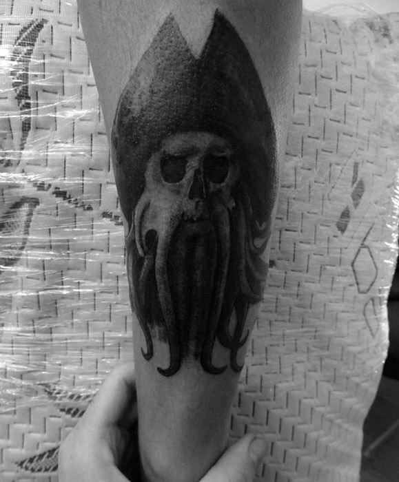 Tattoo of Davy Jones' skull with a tentacled beard on an arm