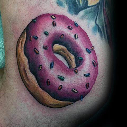 Tattoo of a realistic pink frosted donut with colorful sprinkles and smooth shading for a 3D effect on the skin.