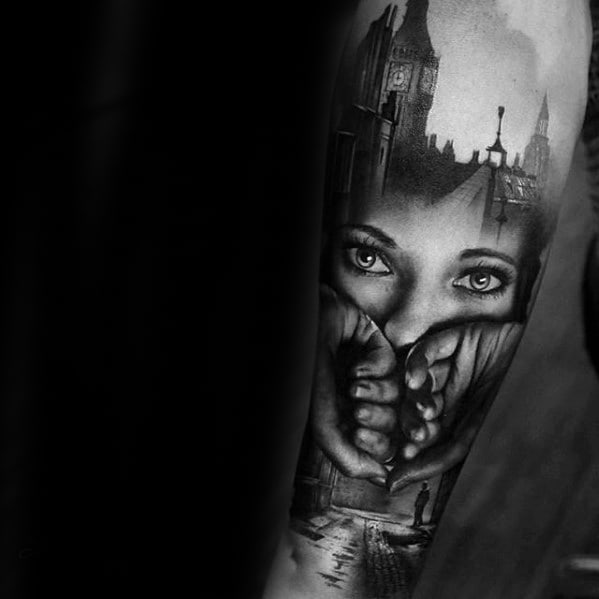 Black and grey tattoo of a woman's intense eyes framed by hands, seamlessly blended with a London cityscape featuring Big Ben and a misty street.