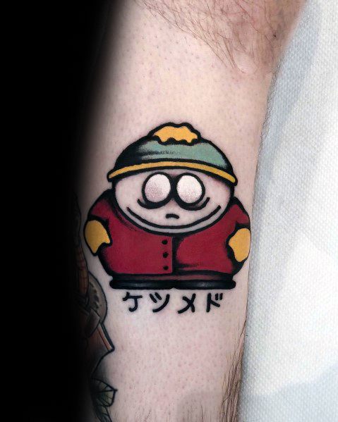 Bold South Park tattoo of Cartman with a Japanese-inspired design, featuring thick outlines, vibrant colors, and Japanese text below.