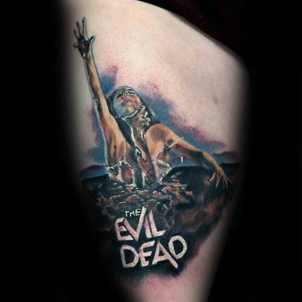 Evil Dead tattoo of the iconic woman reaching from the ground in agony with “The Evil Dead” title below, done in a dramatic, cinematic style