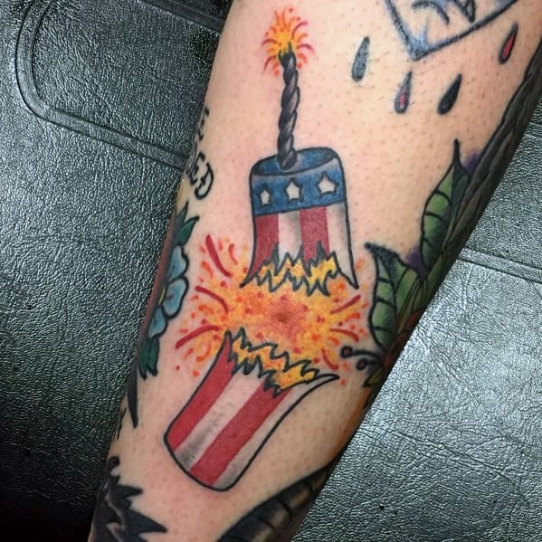Tattoo of an exploding firecracker with an American flag design, bursting with bright orange and yellow sparks in a bold traditional style.
