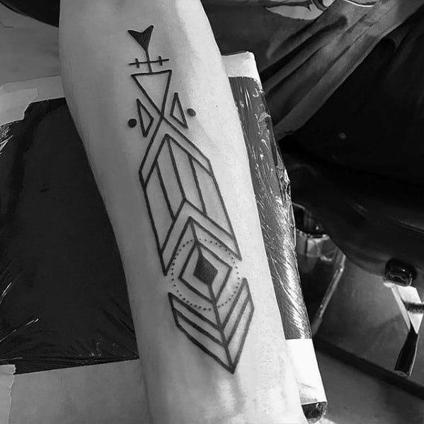Bold geometric arrow tattoo with thick black outlines, layered diamond shapes, and minimal dot accents on the forearm.