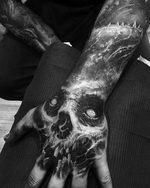 Black and grey realistic hand tattoo featuring a decayed skull design that seamlessly blends into the arm for a haunting and skeletal effect.