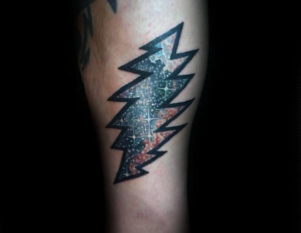 Grateful Dead lightning bolt tattoo with a galaxy and star map design inside, outlined in bold black ink on the calf.