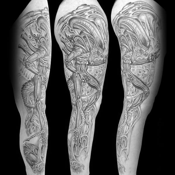 HR Giger-inspired full-leg tattoo showcasing detailed xenomorph figures and biomechanical elements in a surreal, high-contrast design.