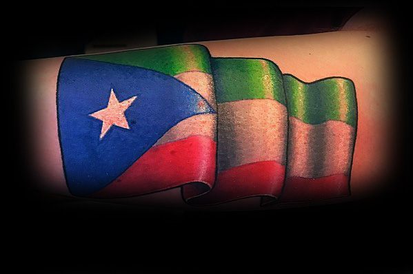 Forearm tattoo of the Puerto Rican and Italian flags waving together, symbolizing pride in dual heritage and cultural identity.
