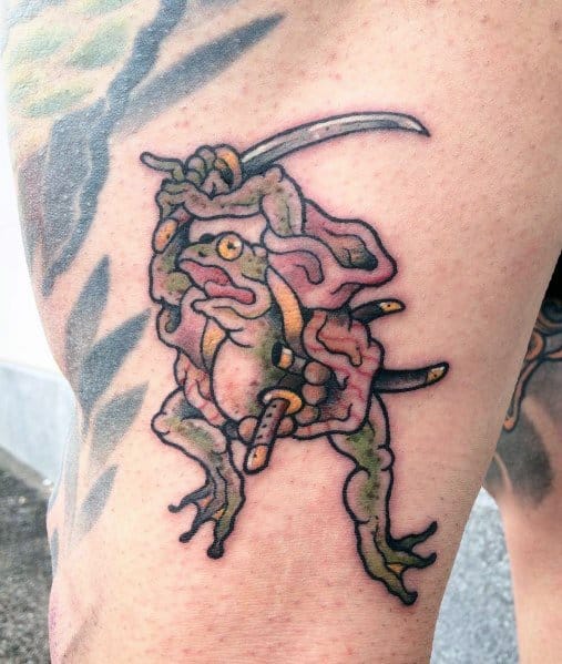 Japanese-style tattoo featuring a warrior frog wielding a katana, dressed in flowing robes with intricate shading, symbolizing strength and resilience.