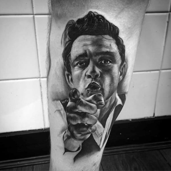 Tattoo of Johnny Cash pointing forward in black and gray on skin