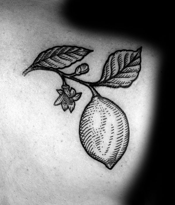 Black ink tattoo of a lemon hanging from a branch with detailed leaves and blossoms, designed in an elegant engraving-style.