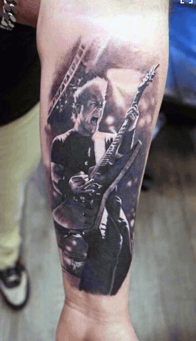 Realistic forearm tattoo of James Hetfield mid-performance, capturing his intense expression and iconic guitar on stage.