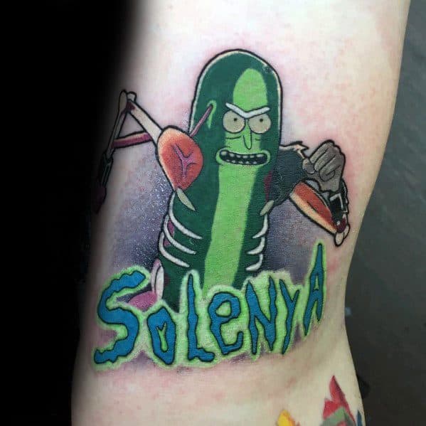 Pickle Rick cyborg tattoo with bold colors, fierce expression, and 'Solenya' text, creating a dynamic and striking design on the skin.