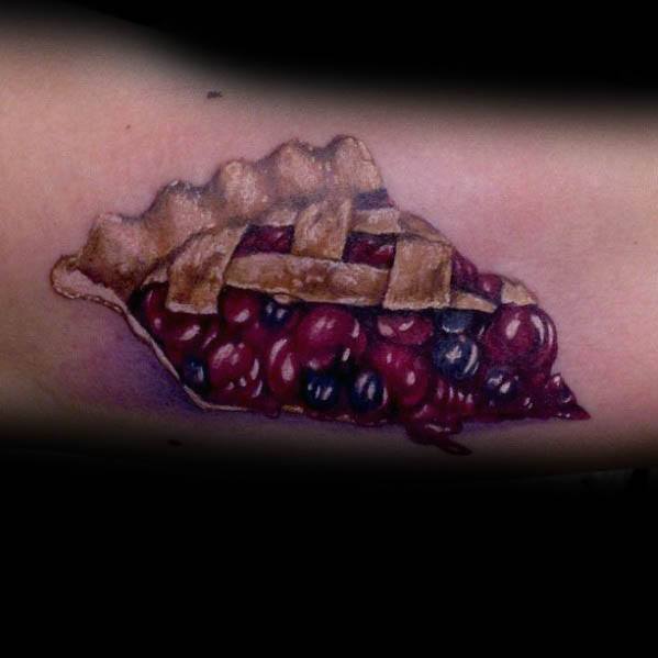 Realistic berry pie tattoo with a lattice crust and oozing cherry and blueberry filling, creating a rich, detailed, and mouthwatering design