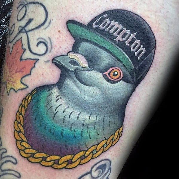 Cool pigeon tattoo with a Compton cap, gold chain, and shades, blending street style and humor in a bold, colorful design.