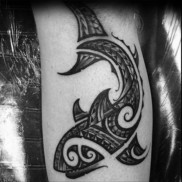 Polynesian shark tattoo on leg with sharp tribal patterns and swirling details symbolizing strength, guidance, and oceanic heritage.