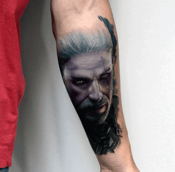 Realistic forearm tattoo of a male character with white hair and intense expression, featuring vivid colors and shadow details