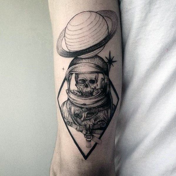 Black line Saturn tattoo design for men featuring a skeleton astronaut inside a geometric frame with the planet above the helmet.