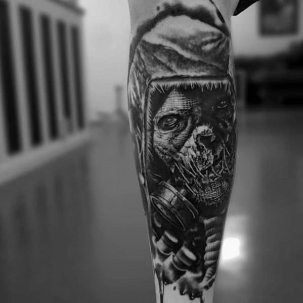 Hyper-realistic scarecrow tattoo with a decaying stitched face, intense eyes, and a gas mask, inked in dark black and grey tones.