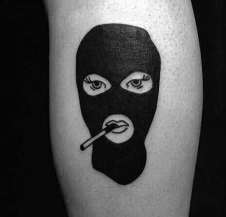 Tattoo of a solid black ski mask with feminine eyes and lips, featuring a cigarette between the lips.