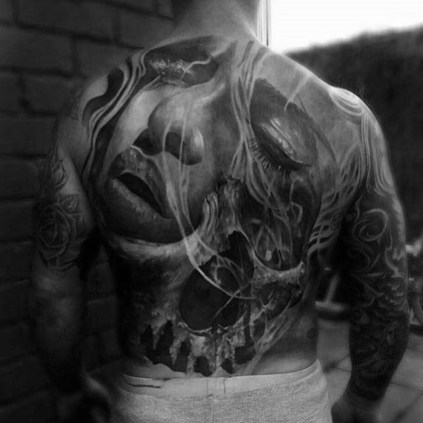 Surreal back tattoo blending a woman's serene face with a decaying skull, symbolizing beauty, mortality, and emotional contrast.