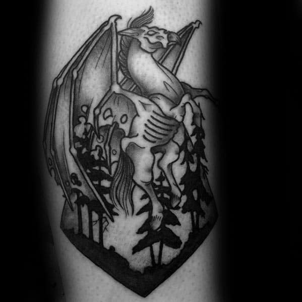 Thestral tattoo in a forest scene, framed within a sharp-edged shape, with bold lines and strong black shading on the leg.