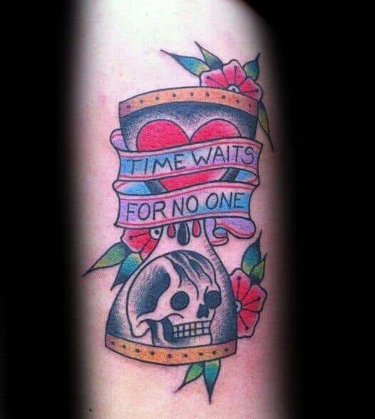 Colorful traditional tattoo with an hourglass, heart, skull, flowers, and a banner that reads Time Waits for No One.
