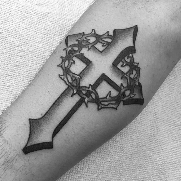 Black and grey tattoo of a bold cross with a crown of thorns wrapped around its center, symbolizing sacrifice and faith.