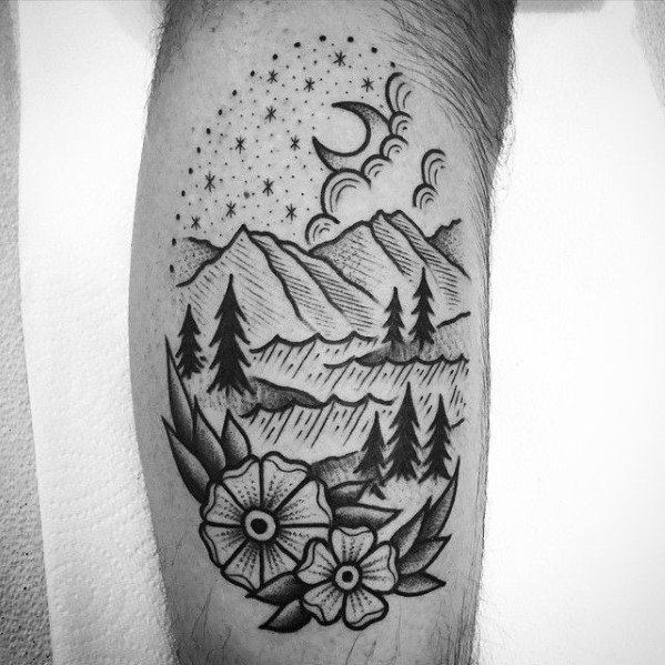 Blackwork mountain landscape tattoo with trees, hills, crescent moon, starry sky, swirling clouds, and detailed flowers at the base.