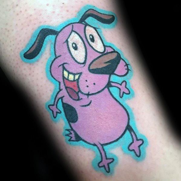 Colorful tattoo of a cheerful Courage the Cowardly Dog with a big smile, outlined in bright blue on a forearm.