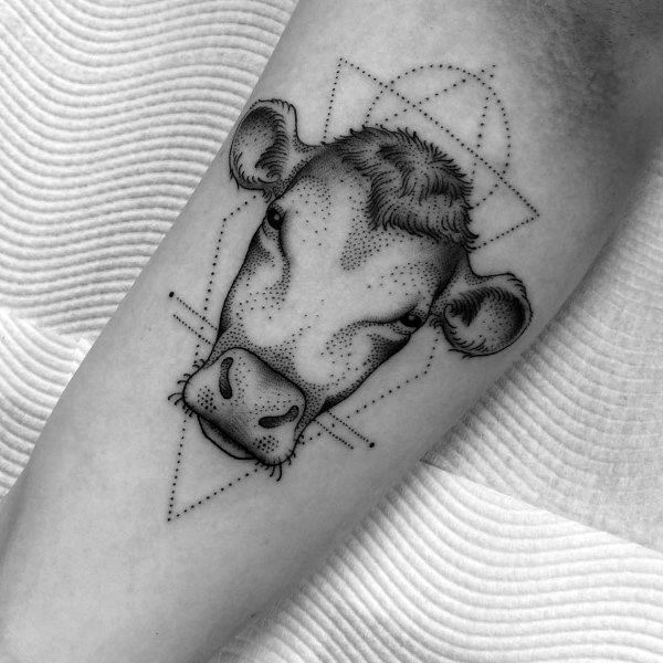 Dotwork cow head tattoo with geometric shapes and fine lines, blending realism and minimalism on the forearm.