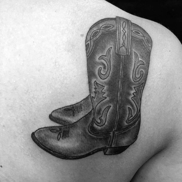 Black and white tattoo of a detailed cowboy boot with classic Western stitching, symbolizing tradition, resilience, and cowboy culture.