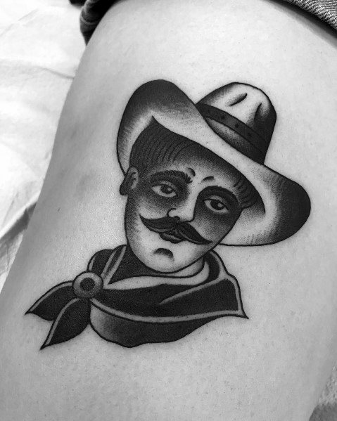 Black and gray tattoo of a cowboy with a mustache, wearing a wide-brimmed hat and bandana, done in a bold traditional style with smooth shading.