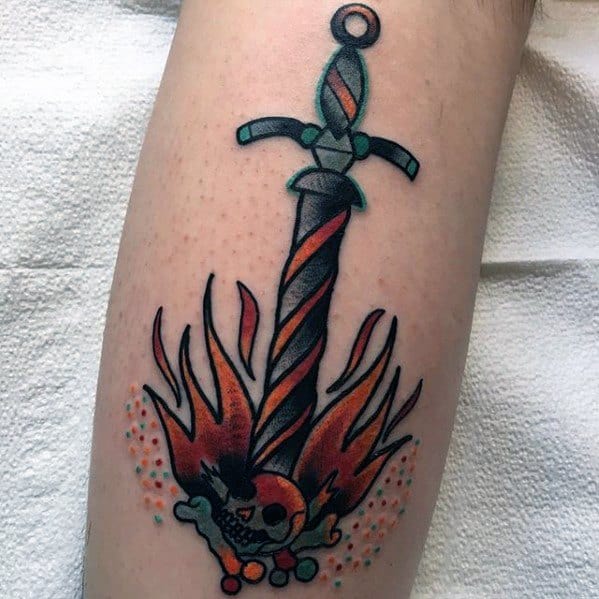 Neo-traditional Dark Souls tattoo of a twisted sword in flames with a skull and bones, accented by bold colors and dotwork.