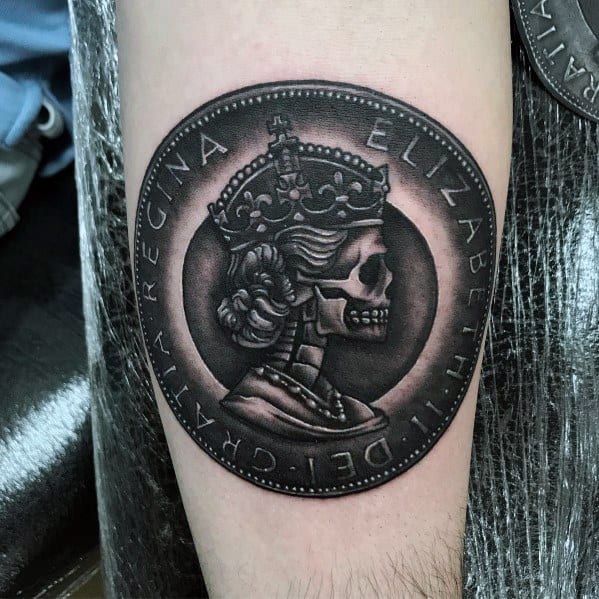 Dark-themed tattoo of a Queen Elizabeth II coin featuring a skeletal portrait, with bold shading for a striking gothic design.